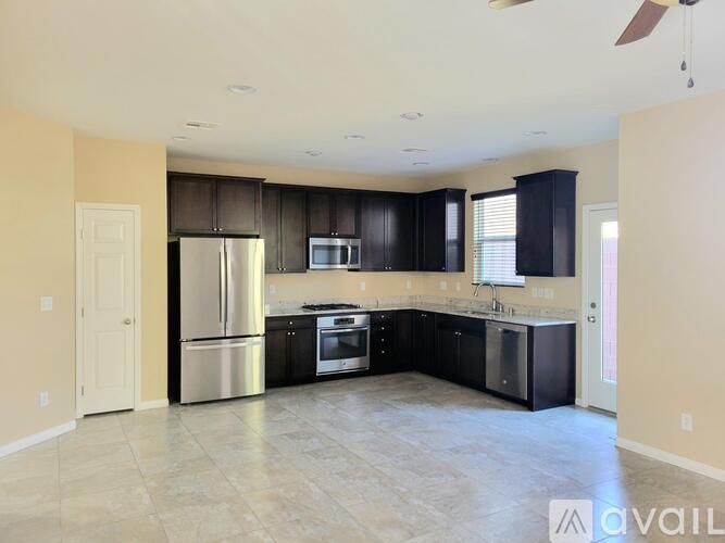 A spacious kitchen with black cabinets and stainless steel appliances.