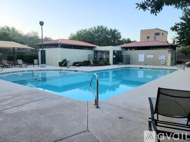 A pool with a chair and a building in the background.