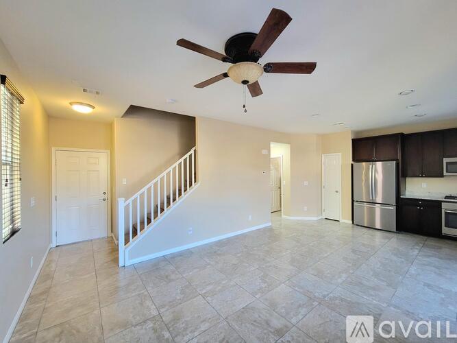 A spacious living room with a staircase leading to the upper floor.