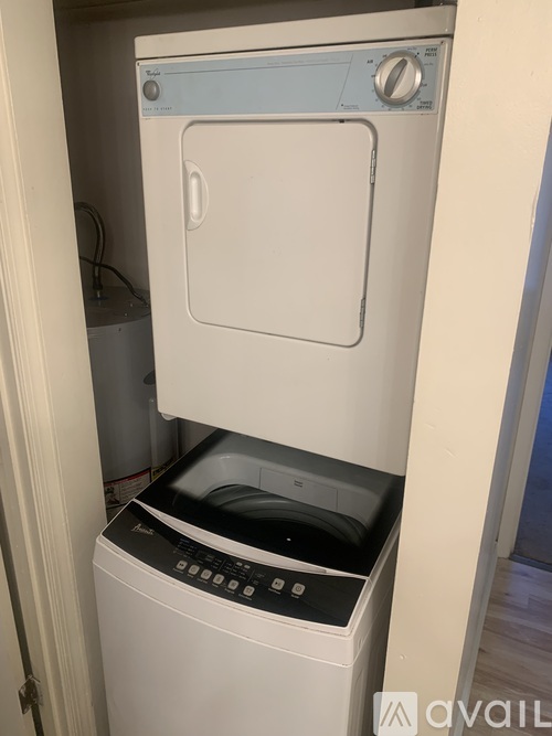 A white dryer is in a small space.