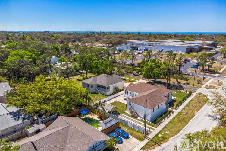 A bird's eye view of a residential area with houses and a swimming pool.