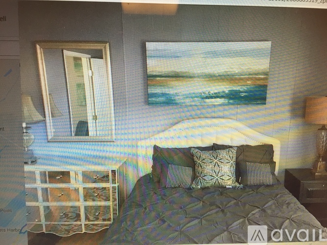A bedroom with a bed, nightstand, and a painting on the wall.