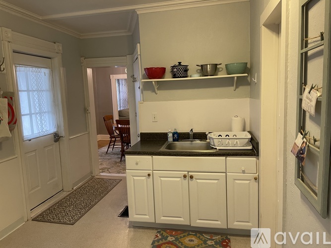 A kitchen with white cabinets and a black countertop.
