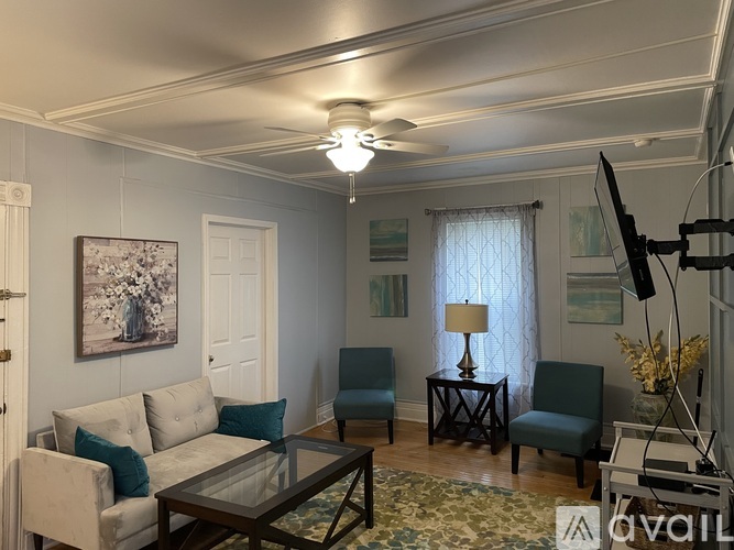 A living room with a couch, chairs, and a coffee table.