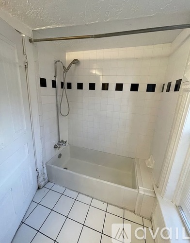 A white bathroom with a bathtub and a shower.