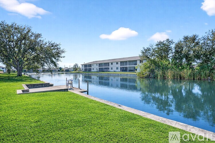 A serene lakeside scene with a building in the background.