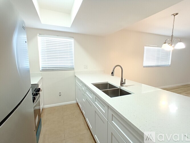 A kitchen with a sink, stove, and refrigerator.