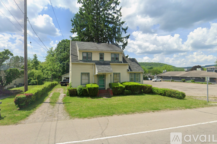 A house with a green lawn and a driveway in front.