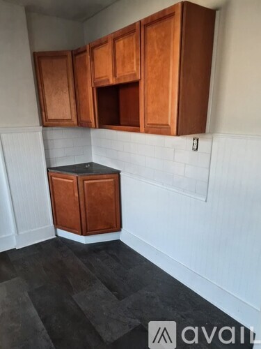 A kitchen with wooden cabinets and a black countertop.