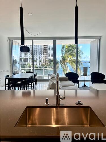 A kitchen with a stainless steel sink and a view of the city.