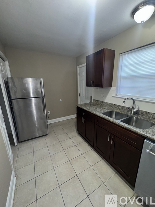 A kitchen with a stainless steel refrigerator and a sink.