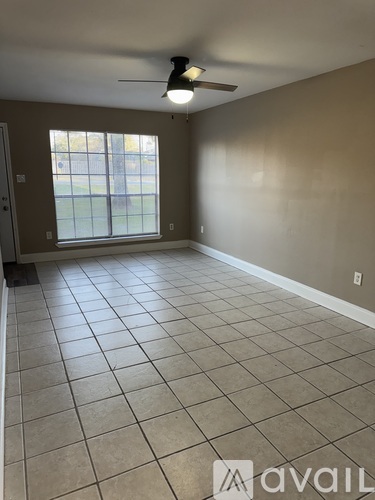 A room with a ceiling fan and tiled flooring.