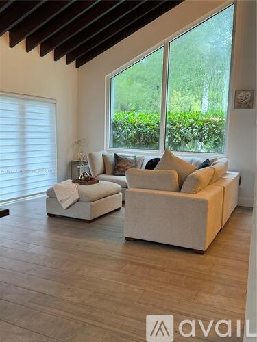 A living room with a white couch and a wooden floor.