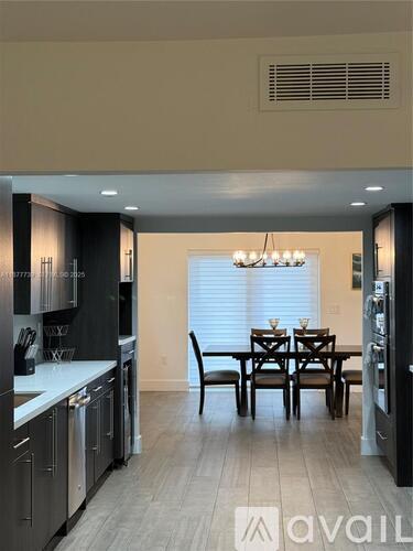 A modern kitchen with a dining table and chairs.