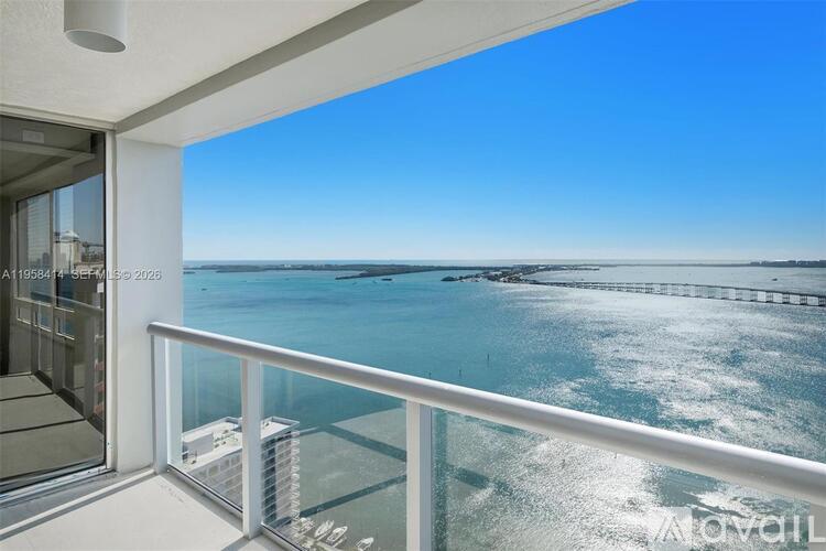 A balcony with a view of the ocean and a pier.