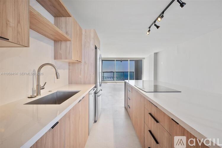 A modern kitchen with wooden cabinets and a stainless steel sink.