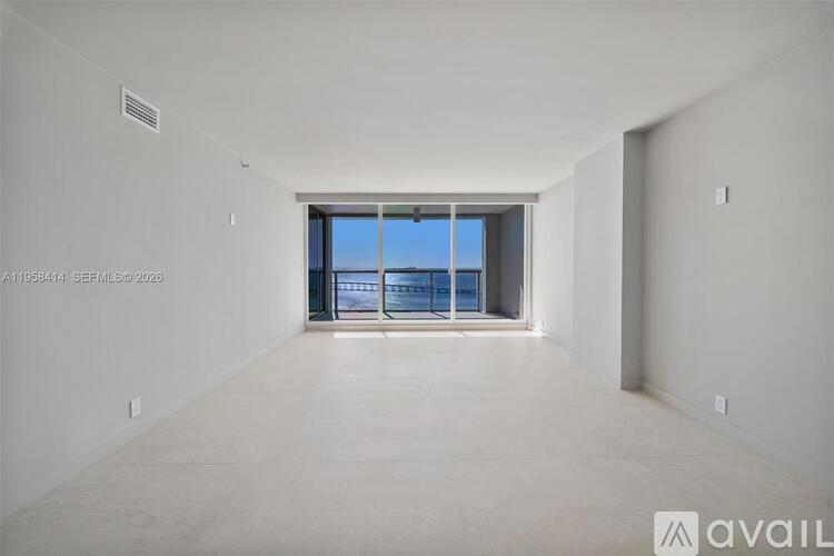 A spacious room with a view of the outside through a large window.