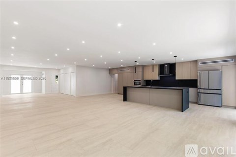 A spacious kitchen with a modern design featuring a large island and stainless steel appliances.