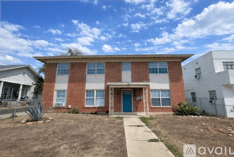 A red brick house with a blue door and windows.