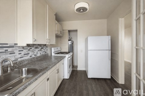 A kitchen with white appliances and cabinets.