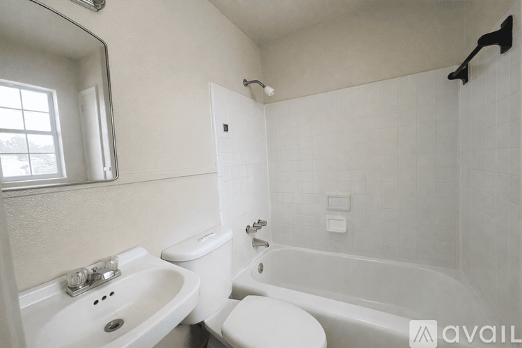 A white bathroom with a toilet, sink, and bathtub.