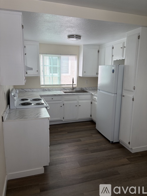 A kitchen with white cabinets and a stove top oven.