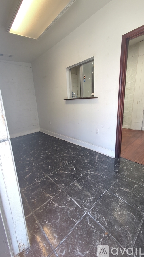 A room with a marble floor and a mirror on the wall.
