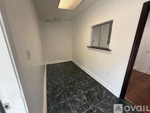 A room with a marble floor and a mirror on the wall.