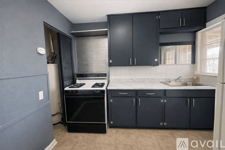 A kitchen with black cabinets and a stove top oven.