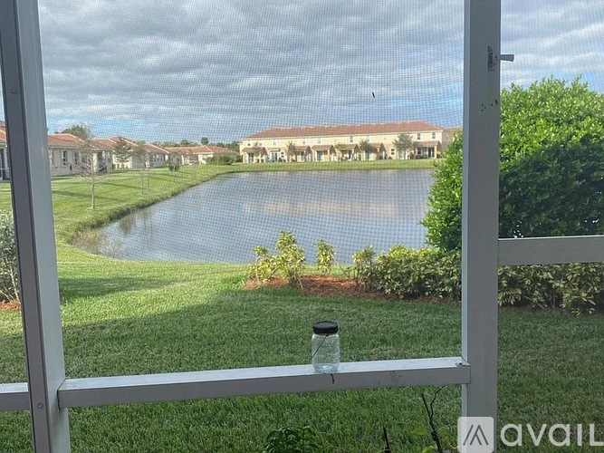 A view from a window looking out at a pond and houses.