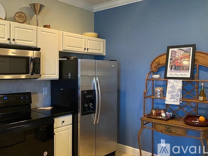 A kitchen with black appliances and white cabinets.