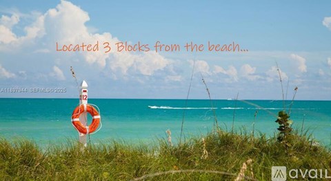 A lifebuoy is placed on the grass near the sea.