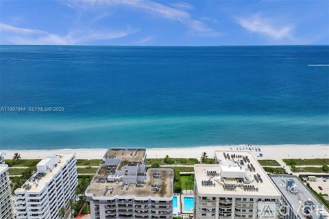 A view of a beachfront with buildings and a pool.