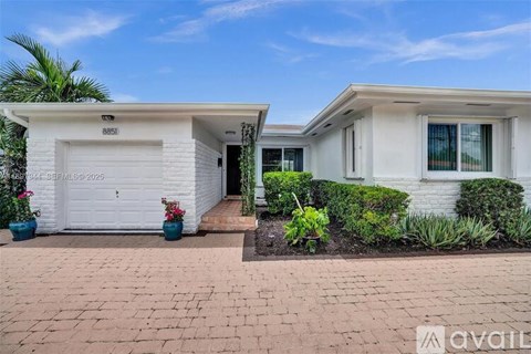A white house with a garage door and a driveway.