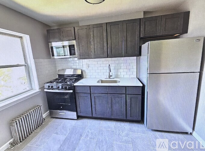 A kitchen with a stove, refrigerator, and microwave.