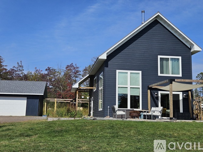 A house with a grey roof and a blue wall is shown.