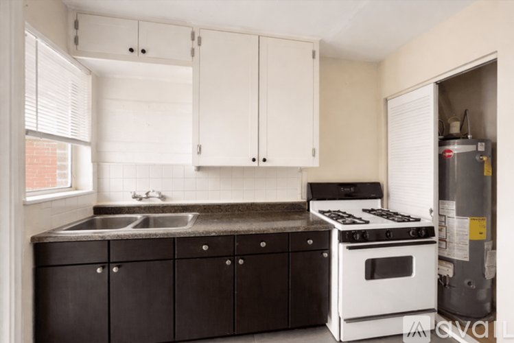 A kitchen with white cabinets and a black countertop.