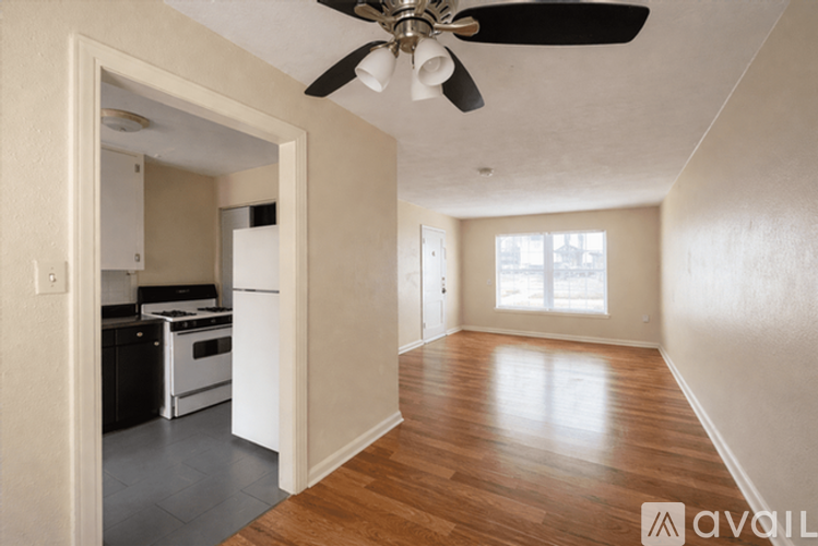 A room with a ceiling fan and wooden floors.