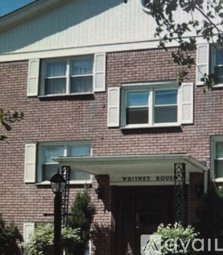 A brick building with a sign that says Whitney House.