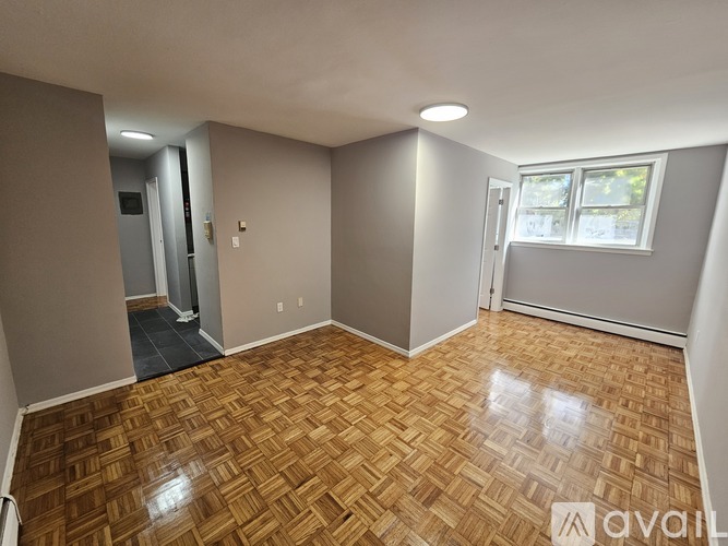 A room with wooden flooring and a window.