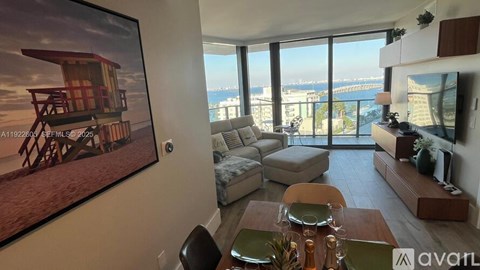A living room with a view of the cityscape through the large windows.