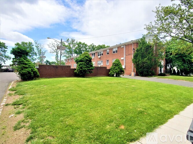 A grassy area in front of a brick building.
