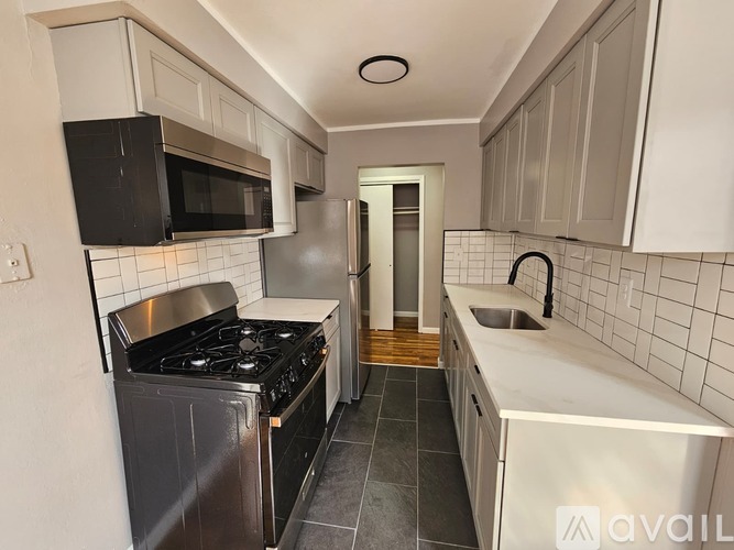 A kitchen with black appliances and white cabinets.