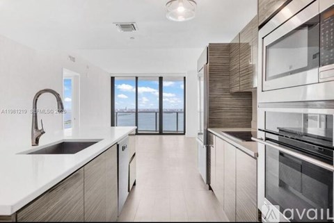 A modern kitchen with a view of the sky through the windows.