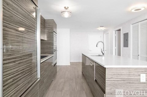 A modern kitchen with a white countertop and wooden cabinets.