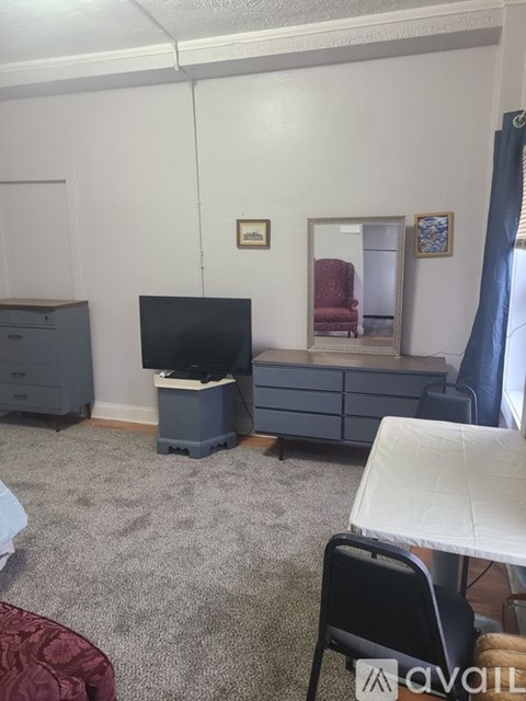 A room with a grey carpet and a white table.