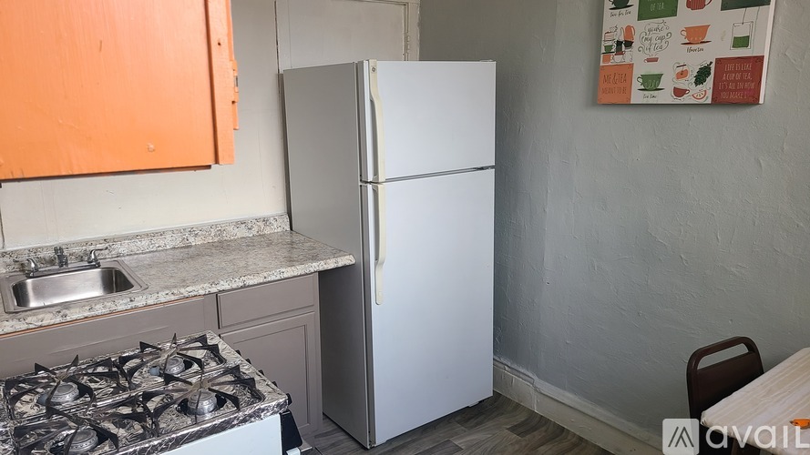 A kitchen with a white fridge, sink, and stove.