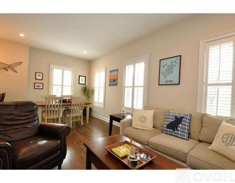 A living room with a brown leather chair and a beige couch.