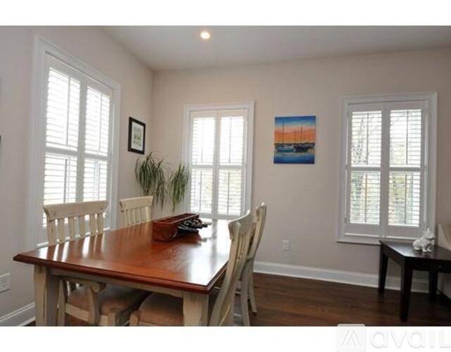 A dining room with a wooden table and chairs.