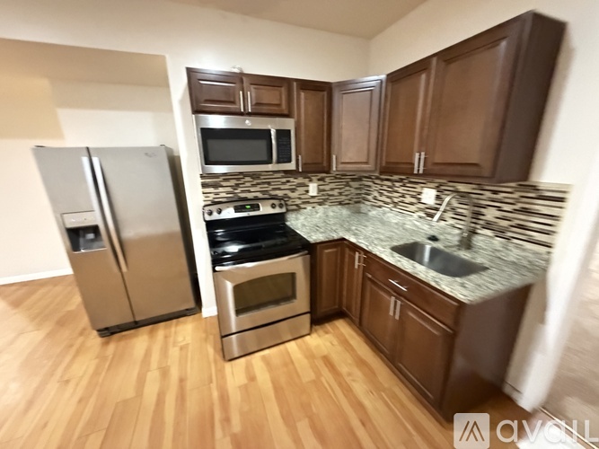 A kitchen with wooden cabinets and a granite countertop.